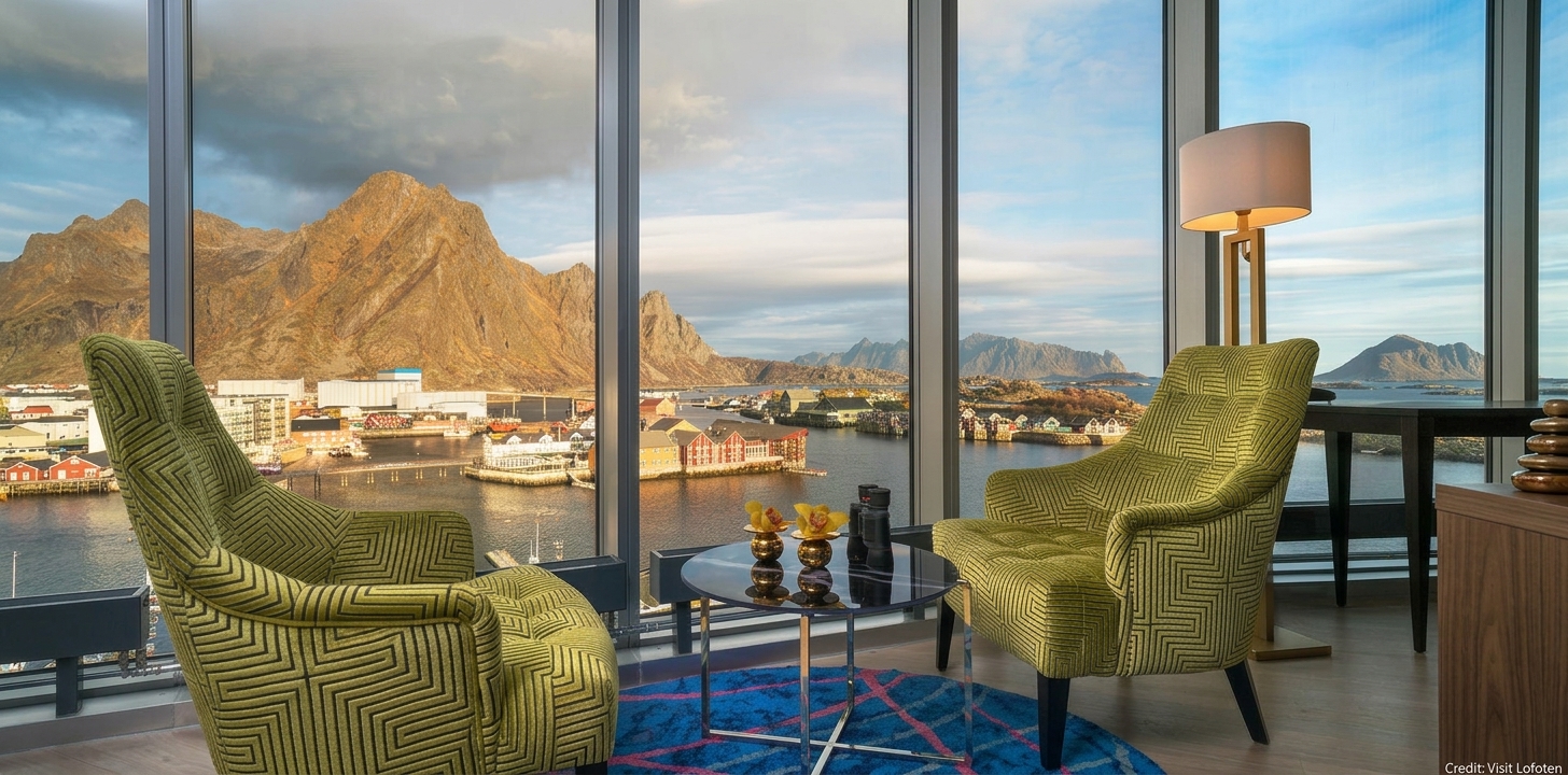 Loungeområde med panoramavindu og utsikt over fjell og havn i Lofoten
