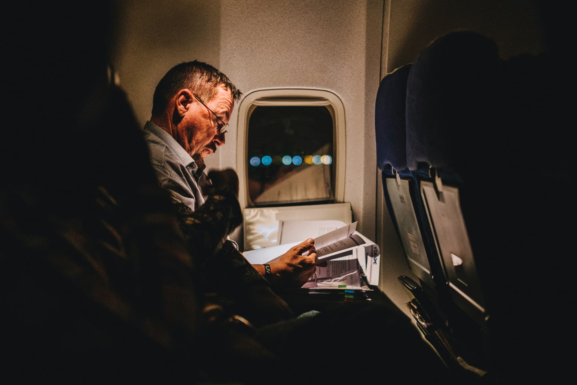 Forretningsreisende som leser dokumenter i flykabinen