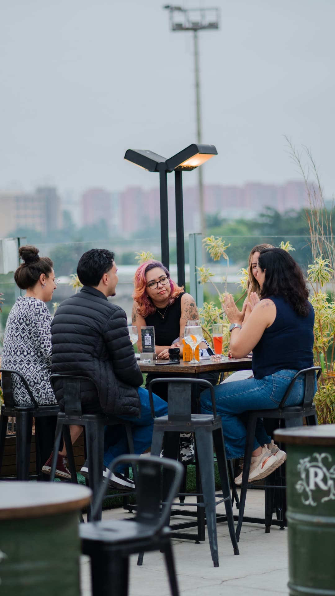 Mindre gruppe i samtale rundt et bord på en takterrasse