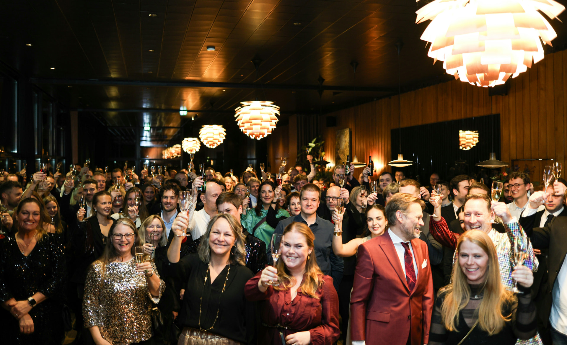 Kolleger hever glassene sammen under en jubileumsfeiring